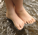 Image of bare feet standing in stream of water