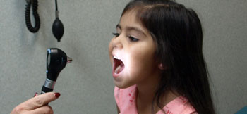 Diseases present in dog waste are easily transmitted to children Image of child being examinted by a medical doctor.