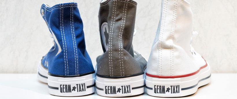 Fecal germs from dog waste are transported everywhere by shoes. Shoes with "Germ Taxi" printed on the back.